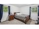 Comfortable bedroom featuring a bed with a plaid comforter, a nightstand, and ample natural light at 1975 Peace Rd, Fort Mill, SC 29715