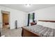 Neutral bedroom with a bed, nightstand, carpet, and a connecting door at 1975 Peace Rd, Fort Mill, SC 29715