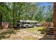 Carport featuring parking for multiple vehicles alongside a brick home surrounded by mature trees at 1975 Peace Rd, Fort Mill, SC 29715