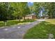 Brick home with a long driveway and carport, set amidst a lush, tree-filled landscape at 1975 Peace Rd, Fort Mill, SC 29715