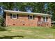 Brick home with dark shutters, a well-kept lawn, and a carport in a lush, green setting at 1975 Peace Rd, Fort Mill, SC 29715