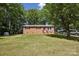Charming brick home with a lush front lawn and convenient carport parking nestled among mature trees at 1975 Peace Rd, Fort Mill, SC 29715