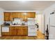 Functional kitchen featuring white appliances, wooden cabinets, and hardwood floors, blending practicality with warmth at 1975 Peace Rd, Fort Mill, SC 29715
