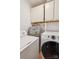 Well-lit laundry room with a washer, dryer, water heater, and white cabinets for storage at 1975 Peace Rd, Fort Mill, SC 29715