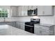Bright kitchen featuring granite countertops, white cabinets, and stainless steel appliances at 207 Giant Oak Ave, Statesville, NC 28677