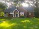Charming brick home with a well-manicured lawn and mature trees, offering a serene and inviting curb appeal at 215 S Belvedere Ave, Gastonia, NC 28054