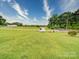 Expansive backyard with white fencing, lush green grass, and mature trees on a sunny day at 2547 Bill Thompson Rd, Lancaster, SC 29720