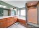 An exceptional bathroom features a tub, a glass shower, a dual sink vanity with beautiful fixtures, and a large window at 2547 Bill Thompson Rd, Lancaster, SC 29720