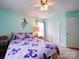 A well-lit bedroom showcases a decorative ceiling fan, a peacock wall hanging, and matching bedding and curtains at 2547 Bill Thompson Rd, Lancaster, SC 29720