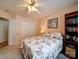 A brightly lit bedroom features a floral bedspread, ceiling fan, closet doors, and a convenient bookshelf at 2547 Bill Thompson Rd, Lancaster, SC 29720