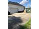 Side view of a home showing a wide driveway leading to a two-car garage and back yard at 2547 Bill Thompson Rd, Lancaster, SC 29720