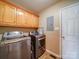 Laundry room featuring front load stainless steel washer and dryer, wood cabinets, tile floors at 2547 Bill Thompson Rd, Lancaster, SC 29720