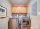 Laundry room with a front load washer and dryer set, wood cabinets, and tile flooring at 2547 Bill Thompson Rd, Lancaster, SC 29720