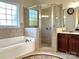 Well-lit bathroom with a soaking tub, glass enclosed shower, and tiled flooring at 3000 J R Ct, Stanley, NC 28164