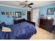 Comfortable bedroom with blue walls, ceiling fan, and decorative pictures, offering a calming personal space at 3000 J R Ct, Stanley, NC 28164