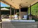 Covered outdoor living space with a TV and comfortable seating for entertainment at 3000 J R Ct, Stanley, NC 28164