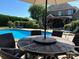 Inviting in-ground pool with a patio dining set, lounge chairs, and a covered outdoor kitchen for relaxing summer days at 3000 J R Ct, Stanley, NC 28164