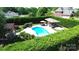 Aerial view of an inviting in-ground pool with a poolside lounge area and lush landscaping surrounded by privacy hedges at 3000 J R Ct, Stanley, NC 28164