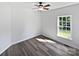 A bright bedroom with durable laminate flooring, ceiling fan, and view of front yard at 3124 Fairmead Dr, Concord, NC 28025