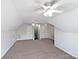 Spacious bonus room featuring neutral carpeting, multiple ceiling fans, and bright, neutral paint at 3124 Fairmead Dr, Concord, NC 28025