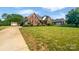 Well-manicured lawn with mature trees, a driveway, and a charming brick house at 3124 Fairmead Dr, Concord, NC 28025