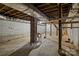 Open unfinished basement featuring exposed beams, with a staircase and potential for renovation at 322 S Vine St, Gastonia, NC 28052