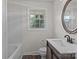 Updated bathroom featuring a modern vanity, a large mirror and a shower-tub combo at 322 S Vine St, Gastonia, NC 28052