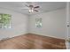 Well-lit bedroom with hardwood flooring, ceiling fan, and inviting natural light streaming through the windows at 322 S Vine St, Gastonia, NC 28052