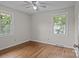 Bright bedroom featuring hardwood floors, ceiling fan, and natural light from the double windows at 322 S Vine St, Gastonia, NC 28052