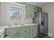 Well-equipped kitchen featuring green cabinets, sleek appliances, and a stainless steel refrigerator at 322 S Vine St, Gastonia, NC 28052