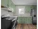 Efficient kitchen featuring green cabinets, modern appliances, and ample counter space at 322 S Vine St, Gastonia, NC 28052