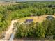 An overhead view of a single Gathering home surrounded by lush green trees, with a long, light-colored driveway at 3650 Sentry Rd, Lancaster, SC 29720
