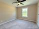A light-filled bedroom features neutral carpeting, a ceiling fan, and a window with a view to outside at 3650 Sentry Rd, Lancaster, SC 29720