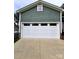 Attached garage with white garage door and green exterior siding at 414 Fulton Dr, Kings Mountain, NC 28086