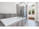 Beautiful bathroom featuring a large tub with tiled surround and a seamless glass shower door at 432 Belton St, Charlotte, NC 28209