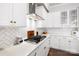 Modern kitchen featuring white cabinetry, stainless steel appliances, and herringbone tile backsplash at 432 Belton St, Charlotte, NC 28209