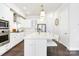 Bright kitchen featuring white cabinetry, a large island with seating, and stainless steel appliances at 432 Belton St, Charlotte, NC 28209