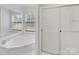 Bright bathroom featuring large soaking tub, glass enclosed shower, and large window at 4328 Camden Rd, Marshville, NC 28103