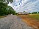 Home exterior featuring gravel driveway and shed with wooded backdrop at 4328 Camden Rd, Marshville, NC 28103