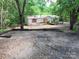 Exterior view of home with wooden ramp, gravel yard, and red shutters surrounded by trees on the property at 4585 Sunrise Beach Rd, Catawba, NC 28609
