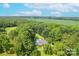 Expansive aerial view showcasing a home surrounded by mature trees and green fields at 4805 Nesbitt Rd, Monroe, NC 28112