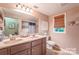 Bright bathroom featuring a double sink vanity, tiled shower and decorative artwork at 4805 Nesbitt Rd, Monroe, NC 28112