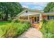Welcoming front porch with colorful flowers and a charming brick walkway entrance at 4805 Nesbitt Rd, Monroe, NC 28112