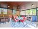 Enclosed patio with ceiling fan, bar and comfortable seating overlooking treed yard at 4805 Nesbitt Rd, Monroe, NC 28112