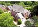 Overhead view of a grand two-story brick home with a gray roof and mature trees adorning the spacious yard at 5827 Rileys Ridge Rd, Charlotte, NC 28226