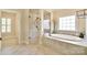 Luxurious bathroom featuring soaking tub, seamless glass shower, and large window with elegant tile design at 5827 Rileys Ridge Rd, Charlotte, NC 28226