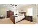 Elegant bedroom with a wooden bed frame, neutral walls, and carpeted floors offers a tranquil and cozy space at 5827 Rileys Ridge Rd, Charlotte, NC 28226