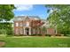 Stunning brick home boasts a lush lawn, complemented by mature landscaping and a classic architectural design at 5827 Rileys Ridge Rd, Charlotte, NC 28226