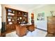 Home office with a built-in wooden bookcase, desk, and neutral color palette at 5827 Rileys Ridge Rd, Charlotte, NC 28226