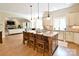 Open-concept kitchen featuring an island with seating, granite countertops, and seamless access to the living room at 5827 Rileys Ridge Rd, Charlotte, NC 28226